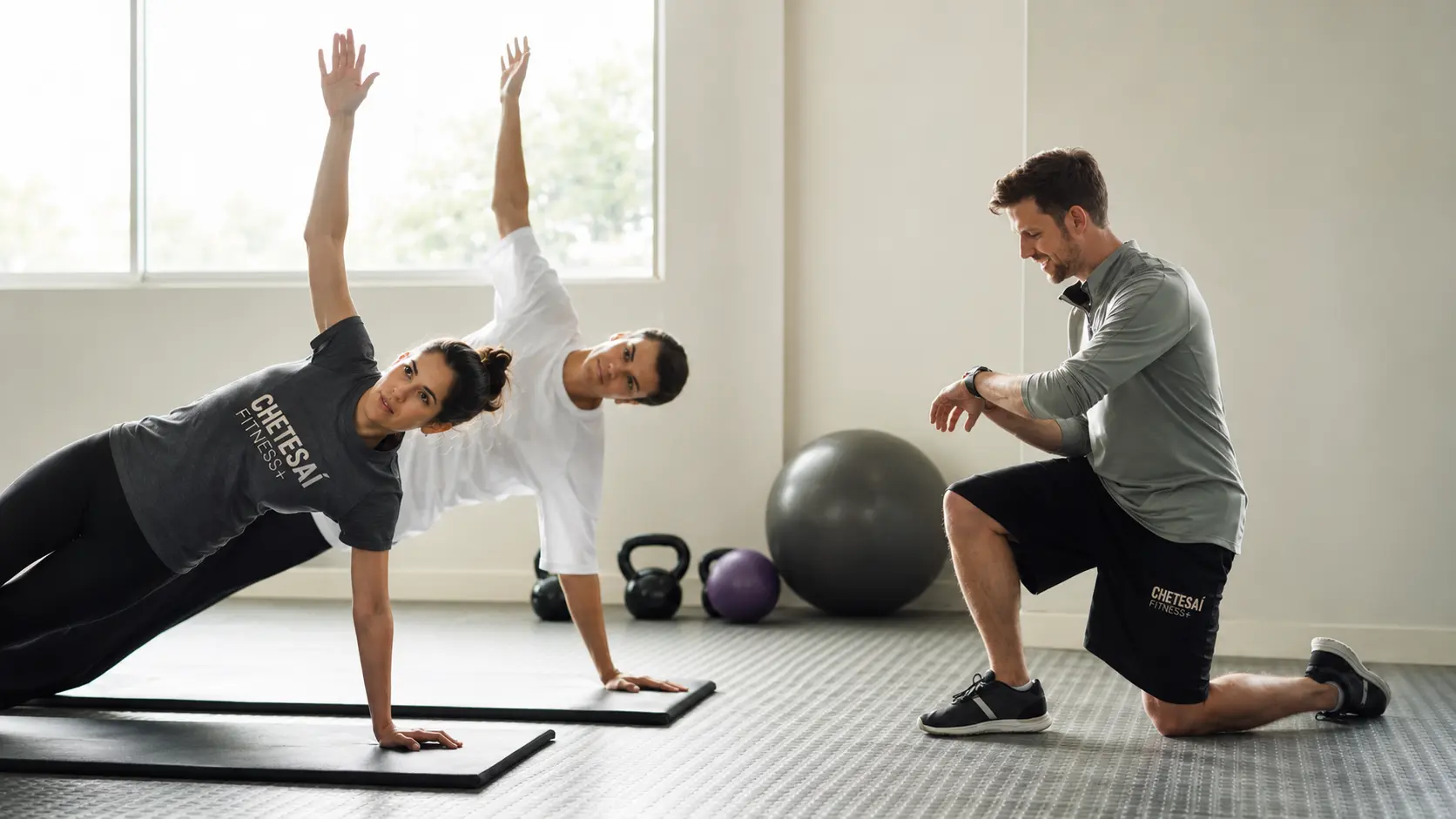 Dos clientas entrenando en grupo con supervisión de un entrenador Chetesaí Fitness+