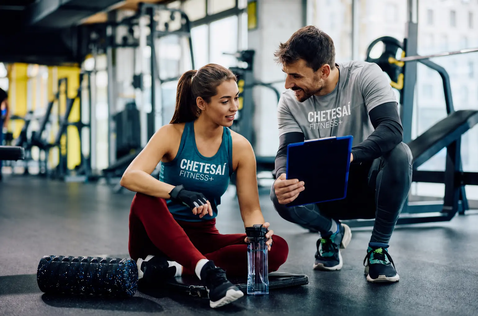 Entrenador y clienta con camisetas Chetesaí Fitness+ durante una sesión de seguimiento